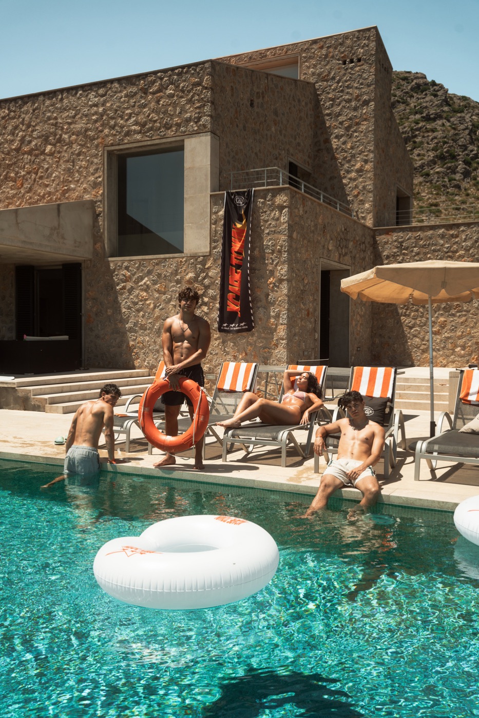 Grupo de jóvenes en una piscina con flotadores